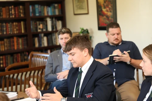 Students discussing around a round table.